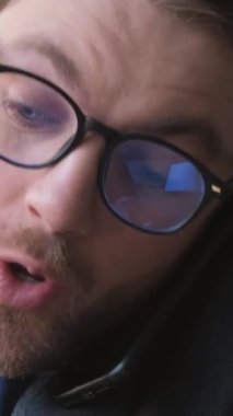 Ofis müdürünün iş yerinde telefonla konuştuğu bir fotoğraf. Dikey video.