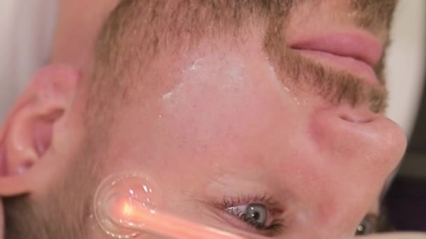 Young Man Undergoes Facial Rejuvenation Procedure Using Darsonval Salon Top — Stock Video