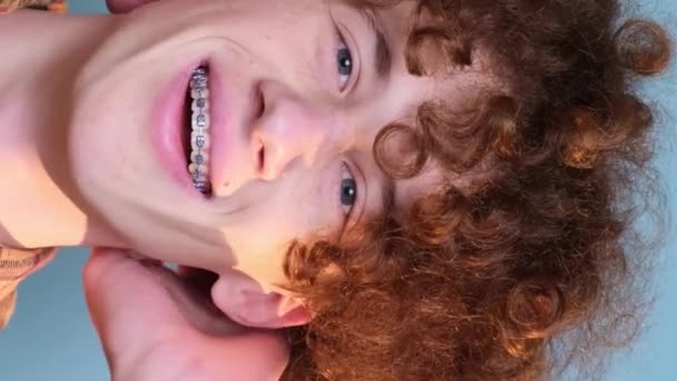Gars Aux Cheveux Bouclés Regarde Caméra Sur Fond Bleu Dans — Video