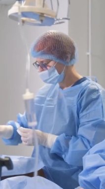 Phlebectomy genel ya da omurilik anestezisi altında yapılır. Cerrahlar klinikte çalışır. Dikey video.