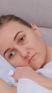 Bunalımlı üzgün kız yorgunluktan gece geç saatlere kadar uyuyamaz. Yaşam krizi, uykusuzluk, uyku bozukluğu. Dikey video.