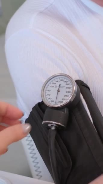 高齢者の血圧を測定する家族医師 バーティカルビデオ — ストック動画