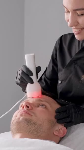 一个年轻人喜欢在美容院里做射频提升手术 在温泉疗养院恢复面部治疗 垂直录像 — 图库视频影像