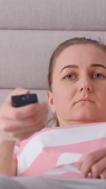 Zmęczona Kobieta Leży Łóżku Ogląda Telewizję Pionowe Wideo — Wideo stockowe