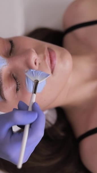 Cosmetóloga Femenina Que Aplica Máscara Cosmetología Azul Las Mujeres Jóvenes — Vídeo de stock