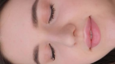 Gözlerini açıp gülen güzel bir Kafkas esmerinin portresi. Dikey video.