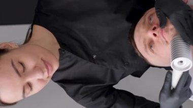 Yüz masajı, Kafkasyalı adam. Deri kriyoterapisi. Tıpta sıvı nitrojen kullanımı. Dikey video.