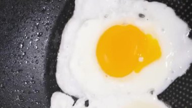 Tavada kızarmış tavuk yumurtalarının en üst görüntüsü. Kahvaltı hazırlıyorum. Dikey video.