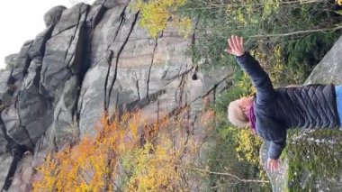 Kadın, sonbahar sezonunda parkta dinlenirken doğanın tadını çıkarıyor. Özgürlüğünü ifade eden mutlu özgür kız. Dikey video.