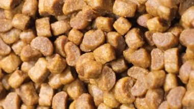 Kuru kedi maması parçalarını dairesel bir hareketle yakın plan çek. Makro video. Dikey video.