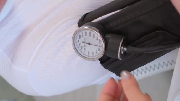 高齢者の血圧を測定する家族医師 バーティカルビデオ — ストック動画