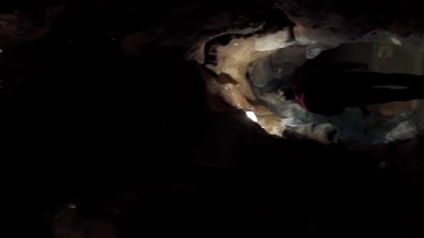 一位专业的施法者照亮并探索了一个黑暗的石洞 垂直录像 — 图库视频影像