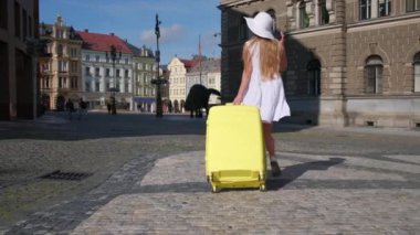 Bavullu bir kadın otele gidiyor. Seyahat ve turizm kavramı.