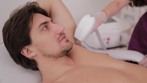 Cosmetólogo Realiza Procedimiento Depilación Láser Axila Guapo Paciente Masculino Salón — Vídeo de stock
