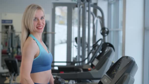 美国女人在健身房的跑步机上锻炼 — 图库视频影像