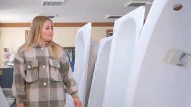 Bir kadın dairesinin içinde metal bir küvet seçer. Daire yenileme konsepti.