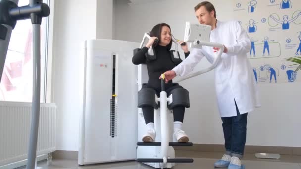 女性患者在椎体治疗中心的理疗师那里检查脊柱 一位妇女和一位医生在一家脊椎诊疗所的模拟器上工作 — 图库视频影像