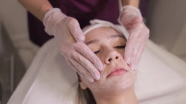 Genç bir kadın güzellik salonunda kozmetik cilt bakımı ve tedavi görüyor. Spa kozmetolojisi ve sağlık rahatlama konsepti. Cilt bakımı.