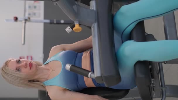 Kvinna Engagerad Gymmet Och Tränar Sina Benmuskler Vertikal Video — Stockvideo