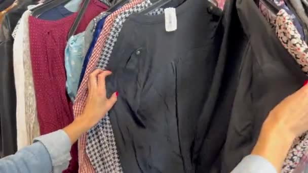 Młoda Kobieta Długimi Włosami Kupuje Używane Ubrania Biedna Kobieta Kupuje — Wideo stockowe