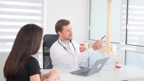 Jovem Médico Conversando Com Paciente Aponta Para Vértebras Modelo Coluna — Vídeo de Stock