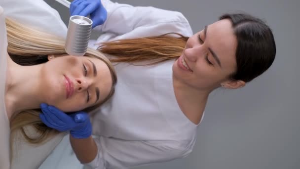 Vídeo Vertical Cosmetologista Faz Uma Massagem Facial Para Uma Jovem — Vídeo de Stock