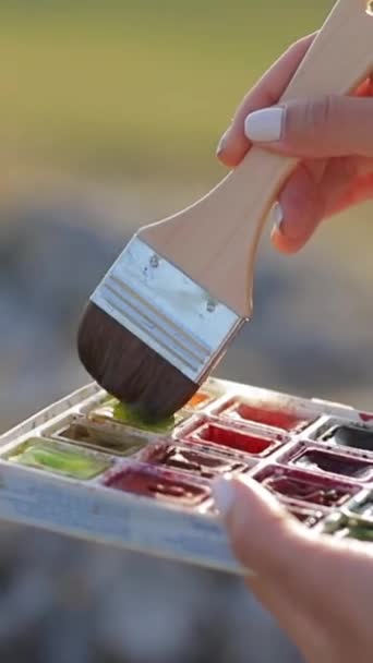 Person Brush Hand Hovers Palette Vibrant Watercolors — Stock Video