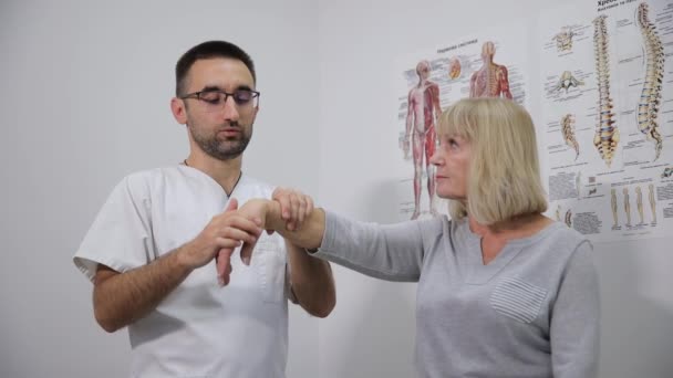Ένας Άνδρας Γιατρός Εξετάζει Χέρι Μιας Ηλικιωμένης Γυναίκας Ασθενούς Νοσοκομείο — Αρχείο Βίντεο