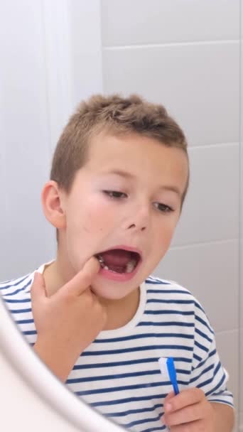 Ein Kleiner Junge Putzt Fröhlich Seine Zähne Und Starrt Sich — Stockvideo