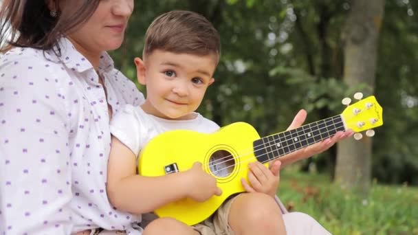 Happy Woman Shares Leisure Time Child Holding Yellow Ukulele Guitar — Stock Video