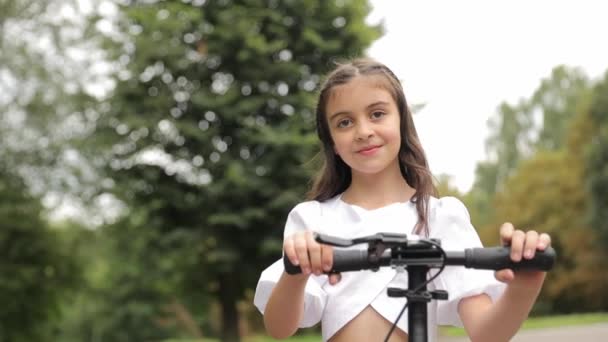 Egy Fiatal Lány Boldogan Lovagol Robogóján Parkban Élvezi Gyönyörű Tájat — Stock videók