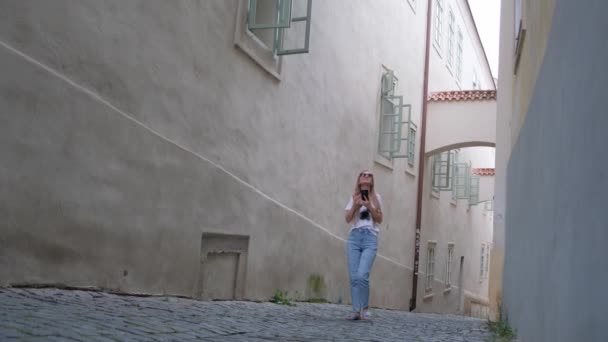 Eine Frau Geht Durch Eine Gasse Mit Gebäuden Auf Beiden — Stockvideo