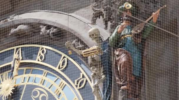 バイオリンを演奏する男を描いたアート作品は 時計の横に立っており 中世の建築と電気ブルーの美学を融合させています — ストック動画