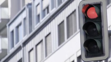 Bir binanın önüne kırmızı bir trafik lambası yerleştiriliyor, ön cephe dekoratif donanımı ve otomotiv aydınlatmasına ekleniyor.