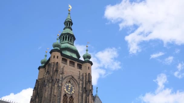 中世の建築で飾られた壮大な時計塔は 青空とふわふわした累積雲の背景にある建物の上に立っています — ストック動画