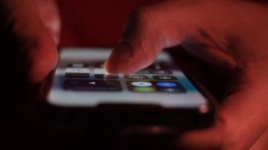 Bir kişi ekranda parmaklarıyla taşınabilir bir iletişim cihazı kullanıyor, muhtemelen bir akıllı telefon ya da cihaz..