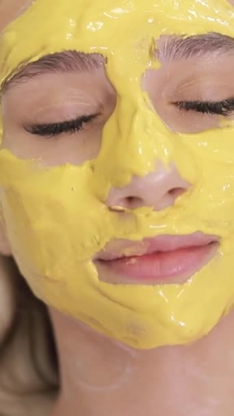 躺在床上 戴着黄色面具的女人躺在她的鼻子和头发上 垂直录像 — 图库视频影像