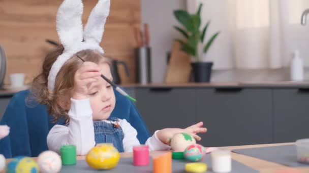 Una Niña Feliz Con Orejas Conejo Está Sentada Una Mesa — Vídeo de stock