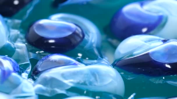 一个可以近距离观察到蓝色电动液体中洗衣粉盘的容器 就像水一样 其图案和颜色与海洋生物相似 但突出表明塑料在此类产品中的使用 — 图库视频影像