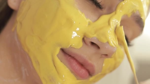 Kosmetolog Tillämpar Gul Guld Alginat Mask Med Spatel Ansiktet Kvinna — Stockvideo