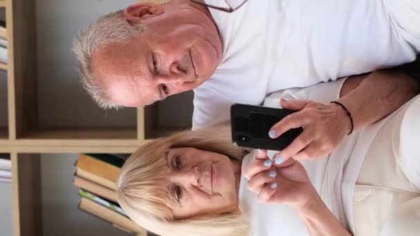 Pasangan Lansia Dengan Senang Hati Berbagi Senyum Sambil Duduk Sofa — Stok Video