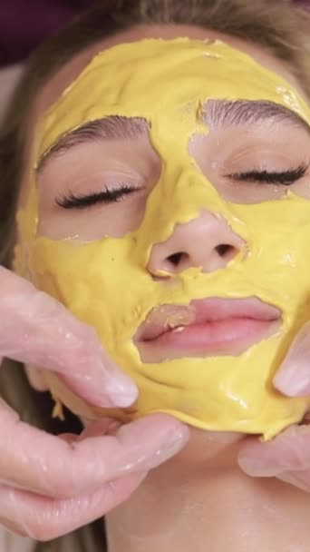 Egy Nőnek Sárga Maszk Van Arcán Egy Gyógyfürdőben Függőleges Videó — Stock videók