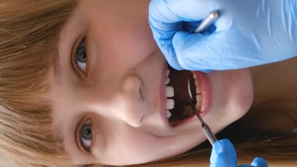 若い女の子は歯科医に歯科検査を訪れ 歯科医は彼女の口 歯をチェックする — ストック動画