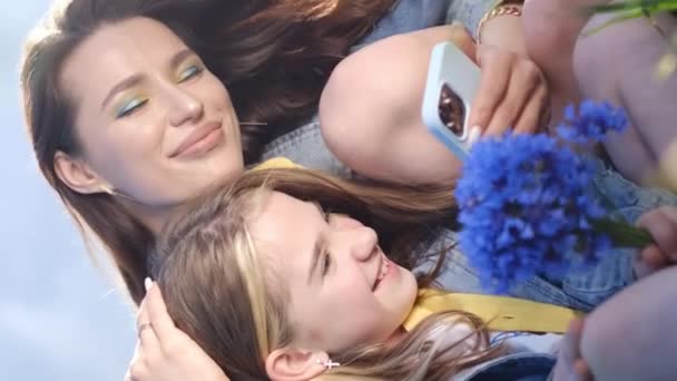 一个快乐的女人和一个小女孩高兴地看着一部手机 他们的笑容折射出迷人的蓝色显示屏 — 图库视频影像