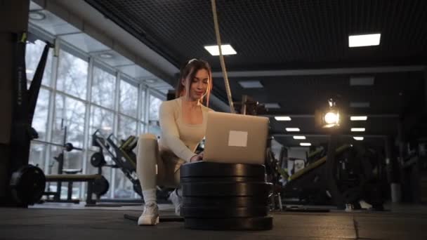 Woman Sits Tire Gym Using Laptop Computer Entertainment While Focusing — Stock Video