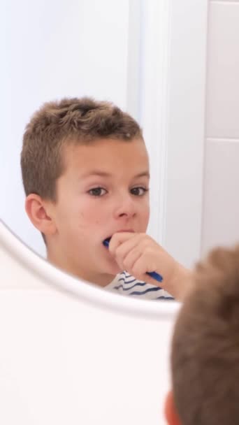 Молодой Мальчик Счастливо Чистит Зубы Любуясь Своим Отражением Зеркале Время — стоковое видео