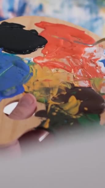 사람은 활기찬 페인트의 배열로 팔레트를 보유하고 활기찬 색상으로 예술적 조리법을 — 비디오
