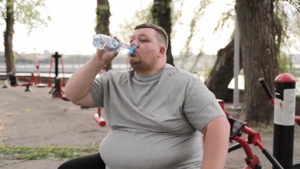 Unavený Mladý Tlustý Muž Šedém Tričku Pije Vodu Láhve Zatímco — Stock video