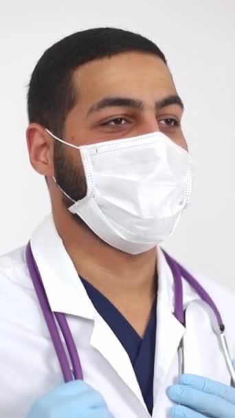 Doctor Donning Personal Protective Equipment Holding Syringe While Wearing Mask — Stock Video