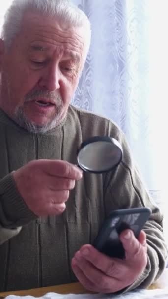 Man Facial Hair Examines Mobile Phone Using Magnifying Glass While — Stock Video